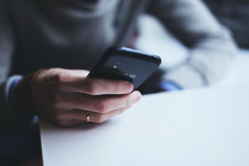スマートフォンを操作する手元