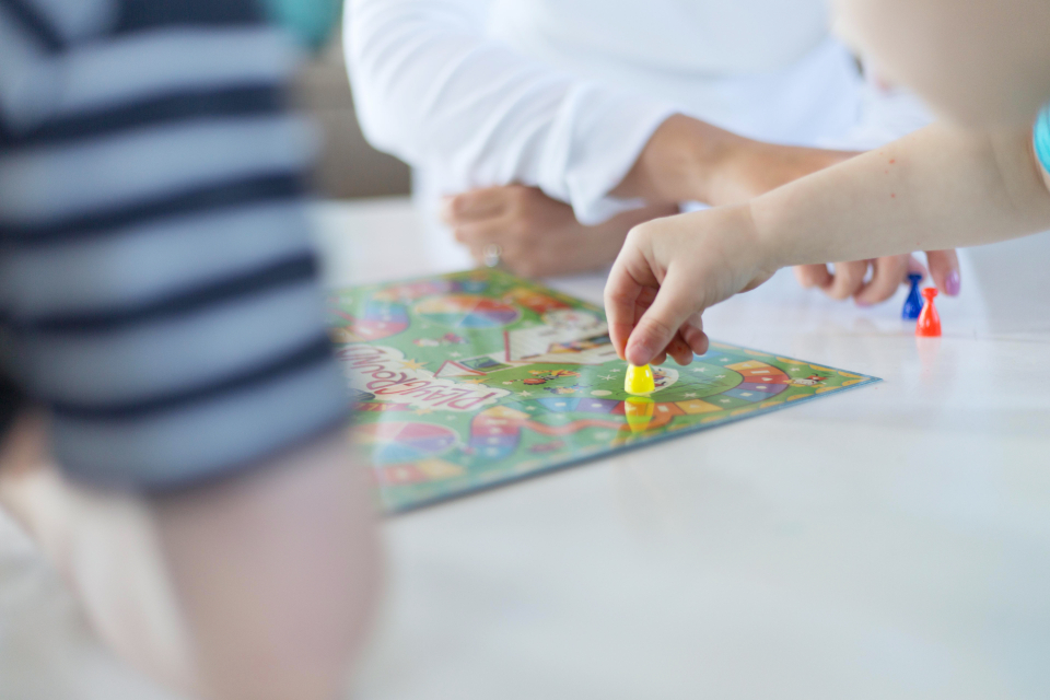 テーブルを囲んでボードゲームで遊ぶ子どもたちの手元