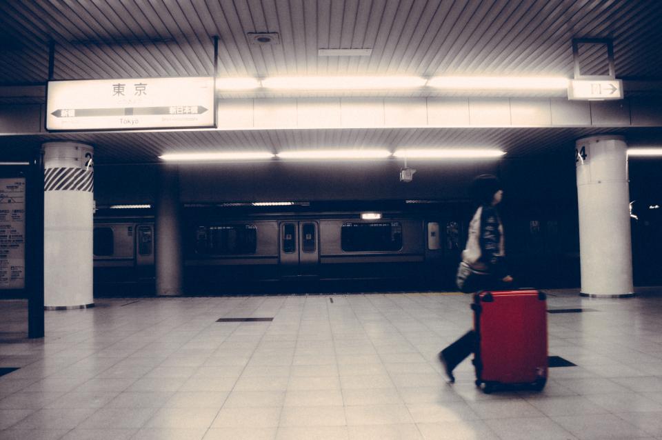 スーツケースを引いて駅構内を歩く旅行者