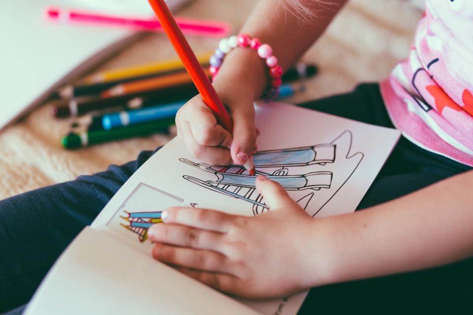 色鉛筆で絵を描く子どもの手元